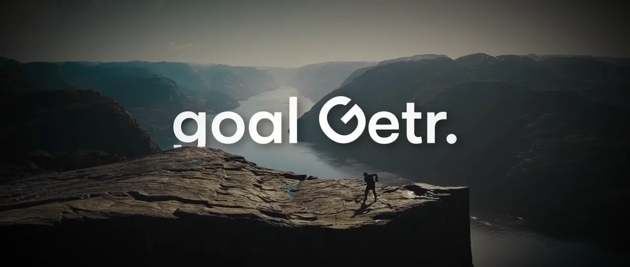 The goalGetr brand film: the wordmark over a hiker on a cliff above a fjord