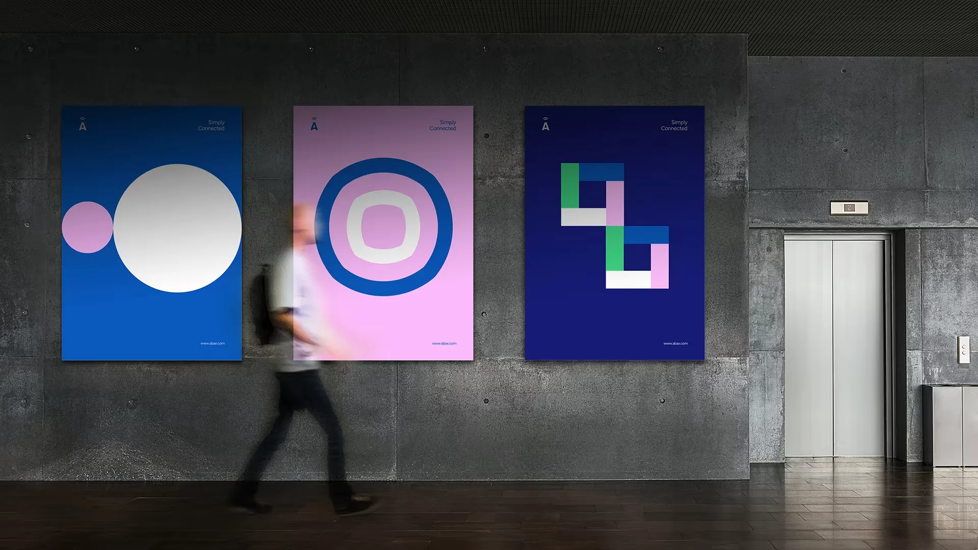 Three ABAX brand posters on a concrete wall, with a person walking past
